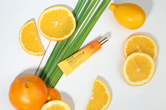Sliced oranges and a dropper bottle of Vitamin C serum